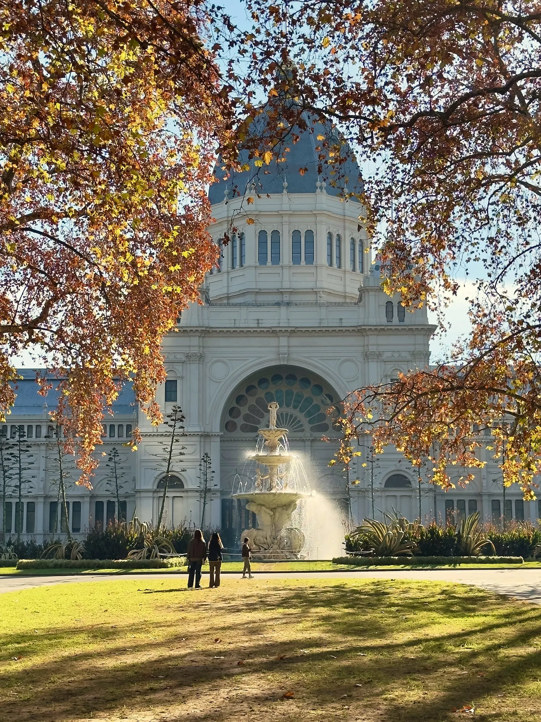 The white dome of the Royal Exhibition Building and its fountain, framed by golden autumn leaves